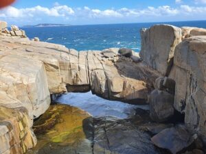 Marvel at the rugged coastal cliffs and natural rock formations, including the stunning granite bridge that spans a gap in the cliffs.